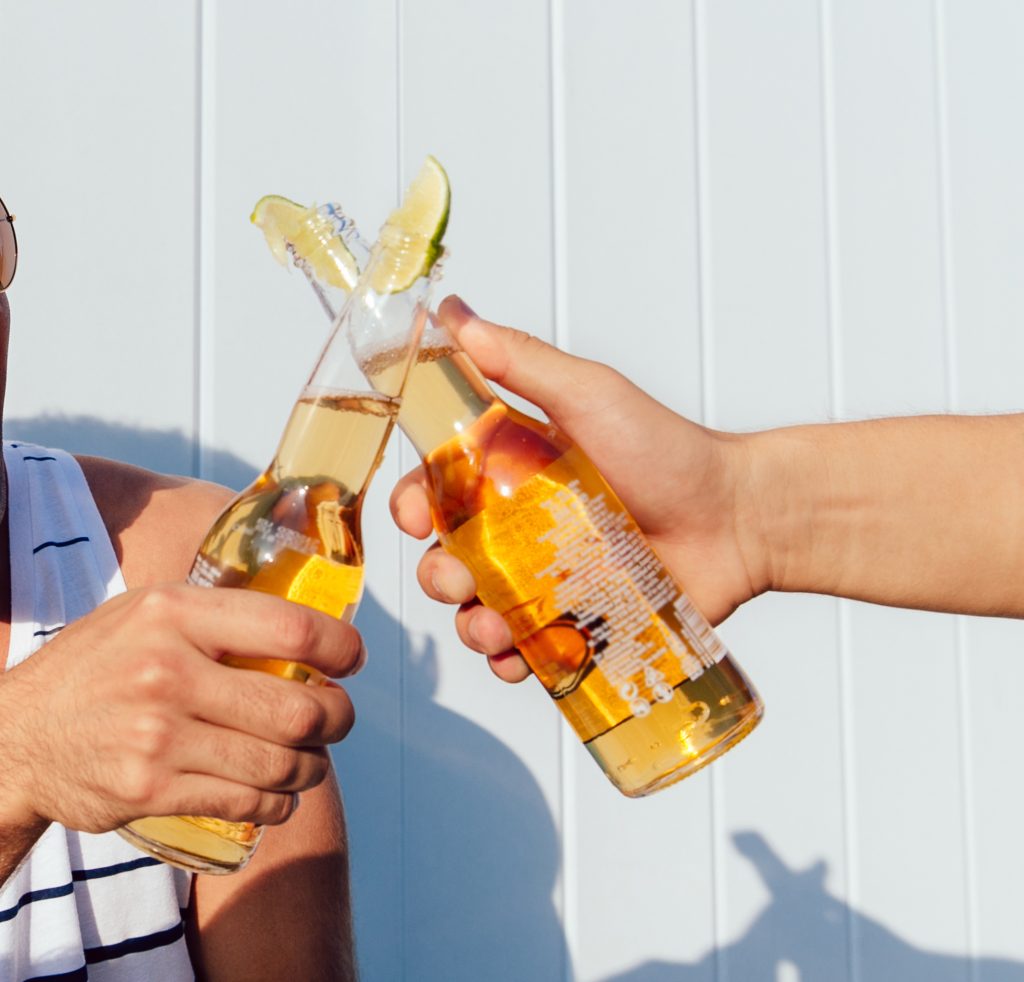 Mãos a segurar em cervejas